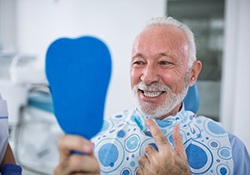 senior man admiring his new smile with dental implants in Downers Grove 