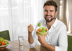 man eating with benefits of dental implants in Downers Grove