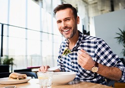 Man eating a healthy meal while smiling
