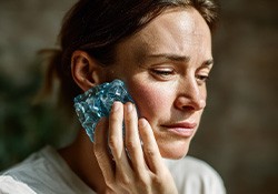 Woman with cold compress on her cheek