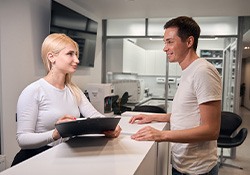Dental team member assisting patient at front desk