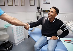 dental patient shaking his dentist’s hand 