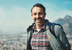 a man smiling with dentures while traveling