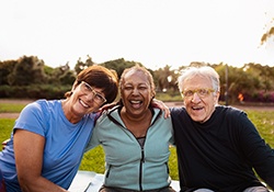 a man with dentures smiling with friends