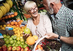 a woman with dentures shopping for healthy fruits