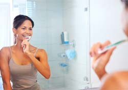 patient brushing teeth in bathroom