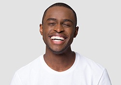 Laughing man in white shirt with straight teeth
