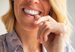 Patient putting clear aligner on top teeth