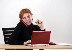 Woman nervously biting pen while working