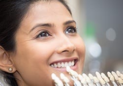 Woman's smile compared with tooth shade chart