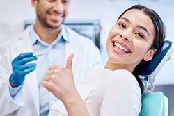 Happy dental patient making thumbs-up gesture