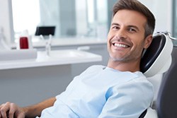 Happy male dental patient reclining in treatment chair
