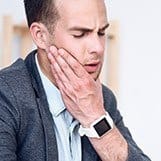 Man holding jaw in pain