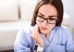 Woman holding jaw in pain
