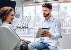 dentist showing a patient information on a tablet