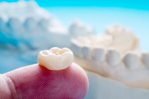 Dental crown held by finger. 