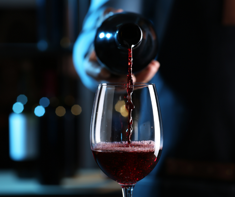 Glass of red wine being poured