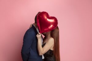 Couple kissing behind a balloon